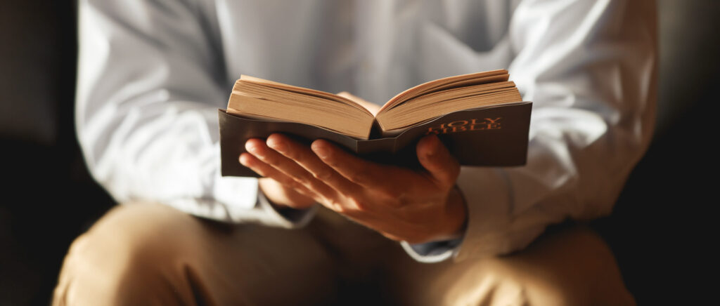 Man The faithful and Christian holding cross is reading th