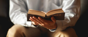 Man The faithful and Christian holding cross is reading th