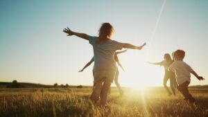 kids run in the park at sunset. friendly family children camp kid dream concept. group of children run on the grass at fun the rays of the sun silhouette. childhood sunset dream teamwork concept